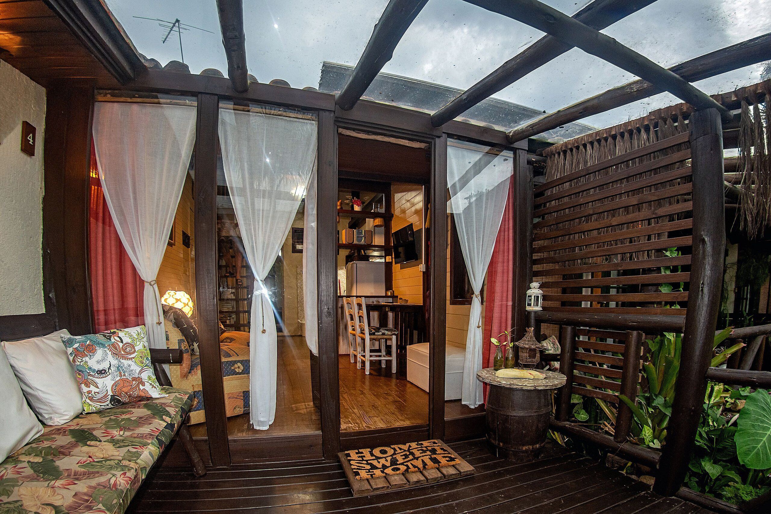 A cozy room with a wooden bench, a small table, and a door leading to a kitchen area.