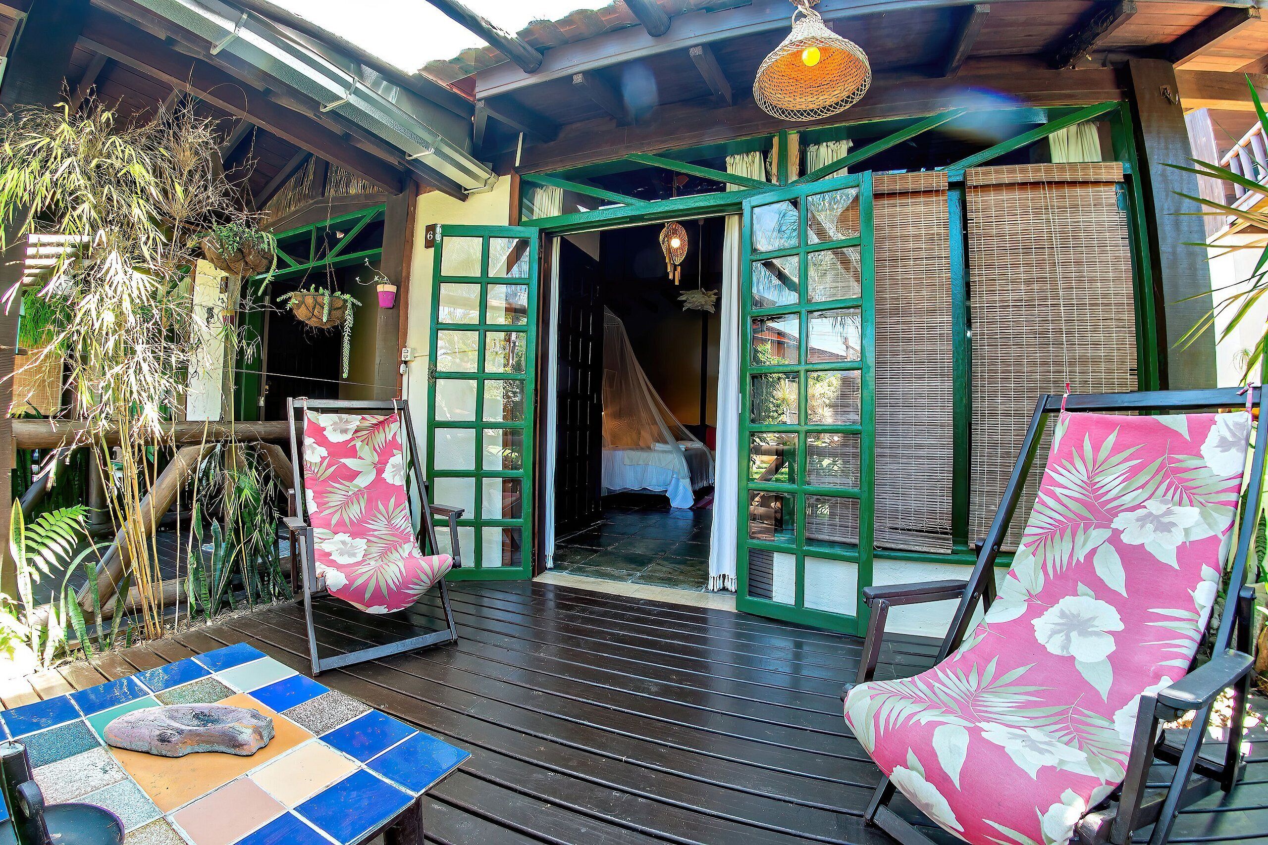 A wooden deck with a tiled floor, a lounge chair, and a table with a stone slab.