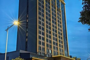 Ein Hochhaus mit einem Raster aus Fenstern, einer Straßenlaterne und einem klaren Himmel.