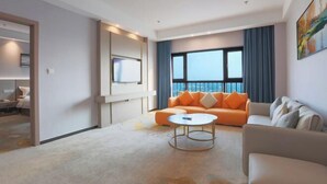 A modern living room with a sofa, a coffee table, and a large window with a view.