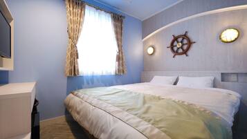 Un dormitorio con cama, ventana con cortinas, un timón de barco sujeto a la pared y una mesita de noche.