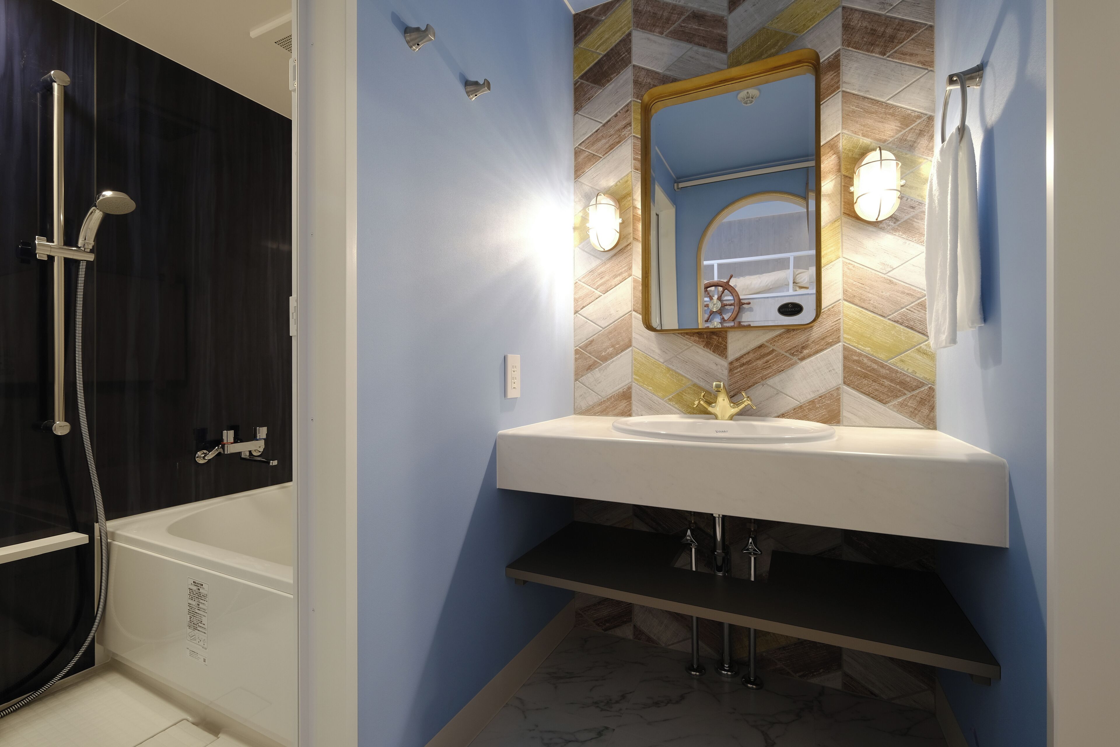 A bathroom with a white bathtub, a sink with a mirror above it, and a showerhead.
