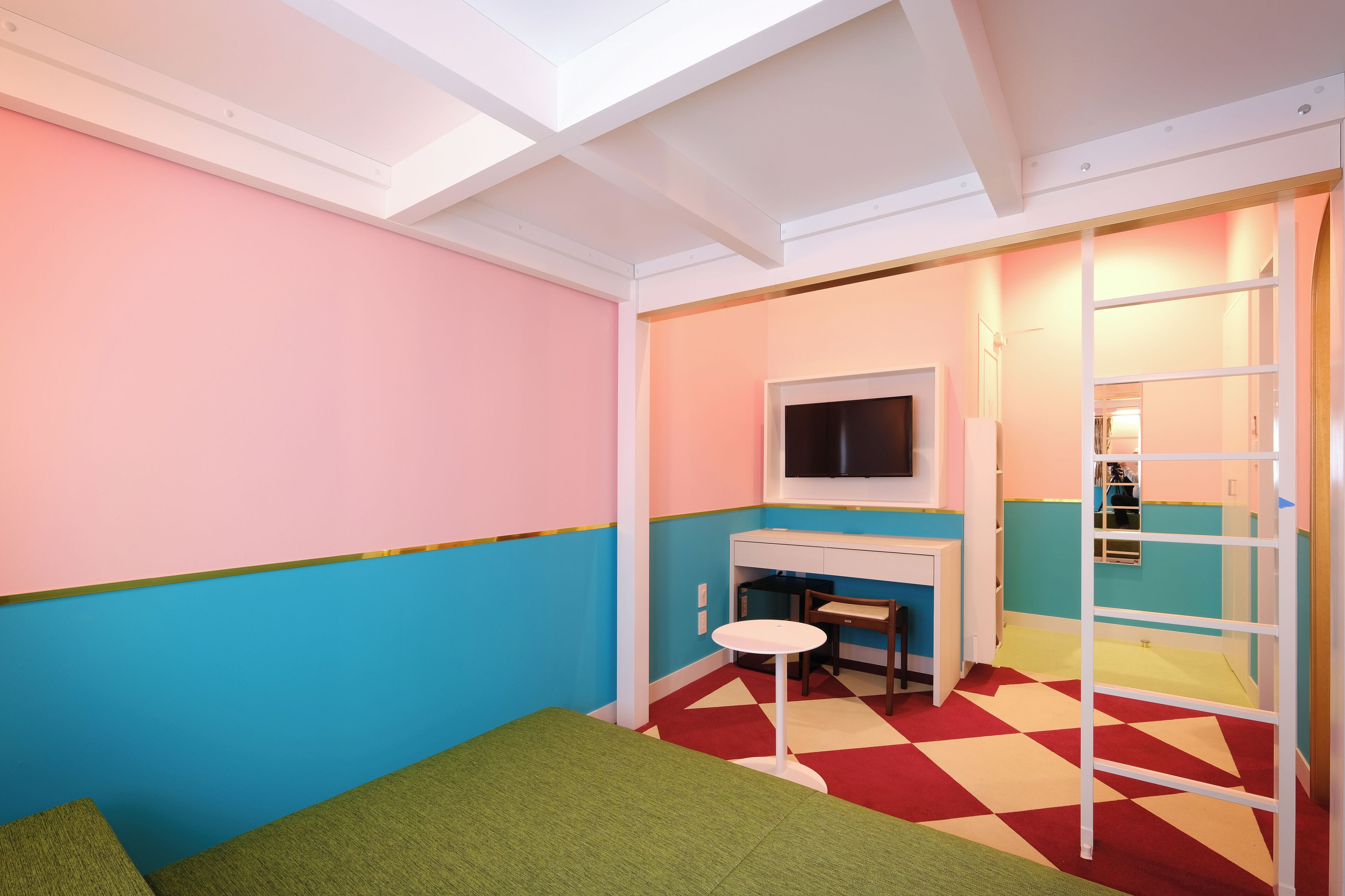 A room with a bed, a desk, a chair, and a TV.