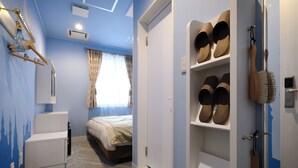 Un dormitorio con cama, armario y zapatero.