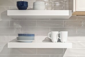 A white shelf with stacked plates and white cups. - Cascade Lodge - Studio Suite (Whistler)