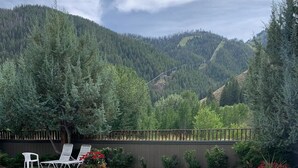 A swimming pool with clear water, surrounded by a wooden deck and a wooden fence. - Beautifully Remodeled Condo in Unbeatable Location! Walk to Gondola & Downtown (Ketchum)
