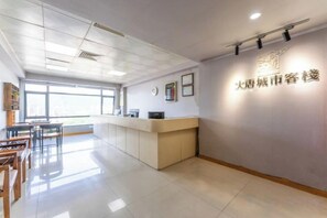 A reception area with a reception desk, a clock, and a wall with signage.