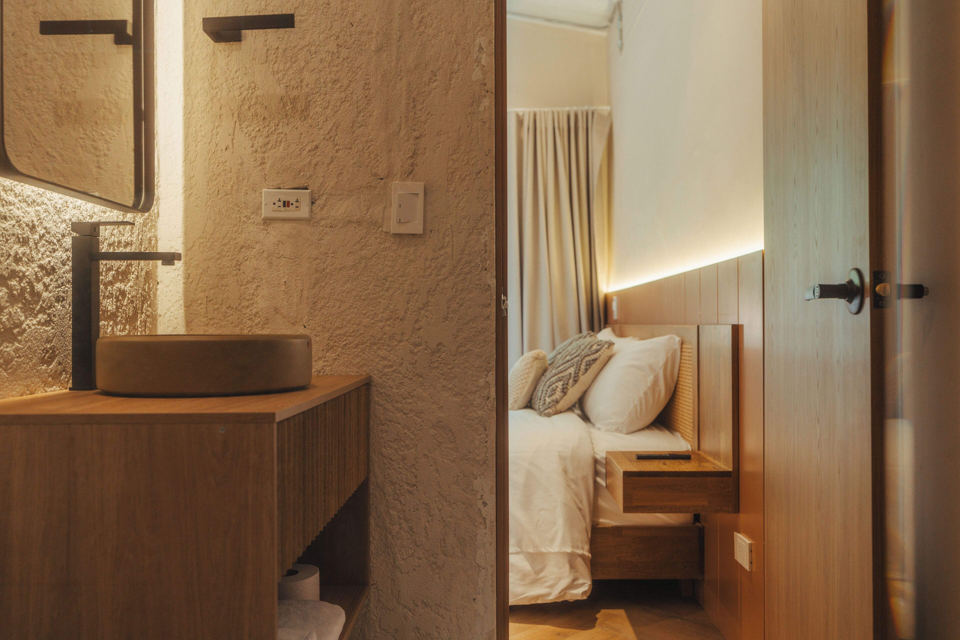 A bathroom with a wooden vanity, a round sink, and a mirror.
