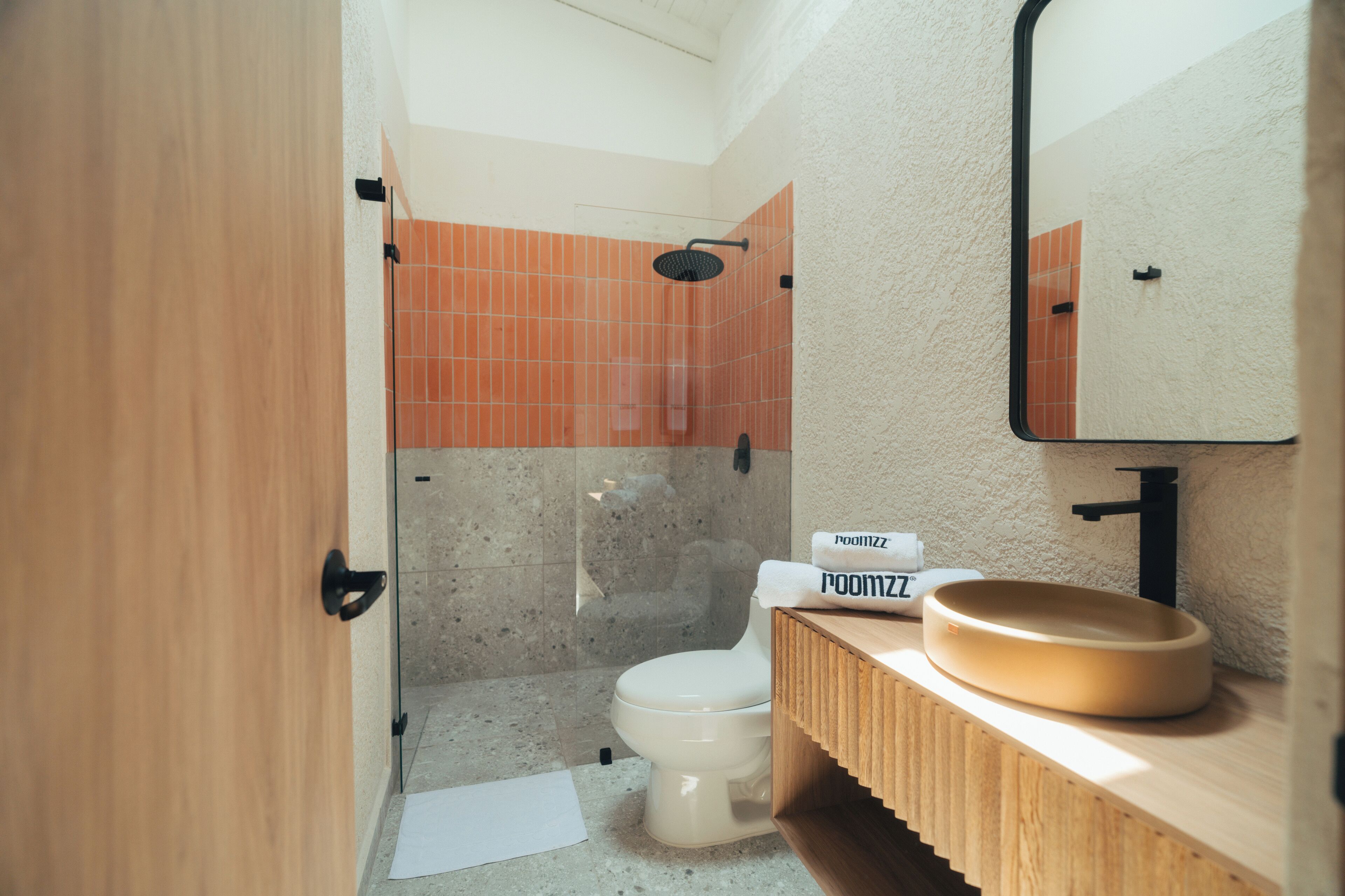 A modern bathroom with a toilet, shower, and sink.