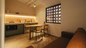 Une cuisine compacte avec un coin repas, une fenêtre ornée de vitraux et un design de plafond moderne.