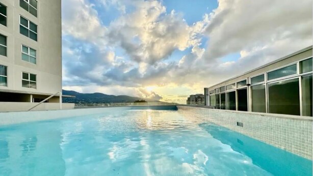 A rooftop pool with a clear view of the sky and distant mountains. - Beautiful and Cozy Studio in San Jose (San José)