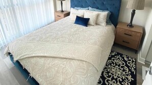 A bedroom with a large bed, two bedside tables, a window with blinds, and a painting on the wall. - GLOBALSTAY. Charming Lake View 1bd+den in Downtown (Toronto/Canada)