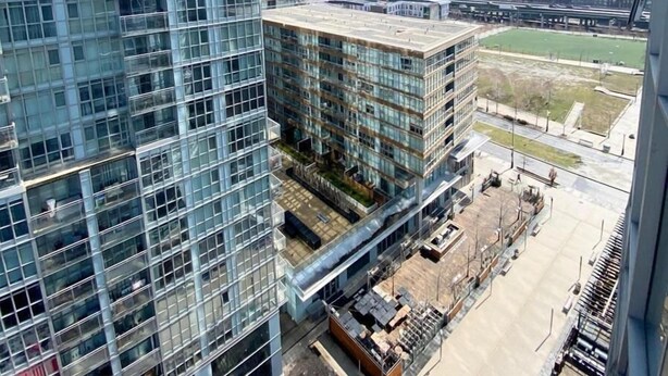 A high-rise building with a glass facade and a view of a construction site below. - GLOBALSTAY. Charming Lake View 1bd+den in Downtown (Toronto/Canada)