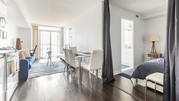 Een moderne hotelkamer met een zithoek, een bank, een bed en een bureau.