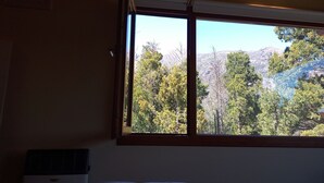 Una stanza con un letto, una finestra e un riscaldatore a parete.