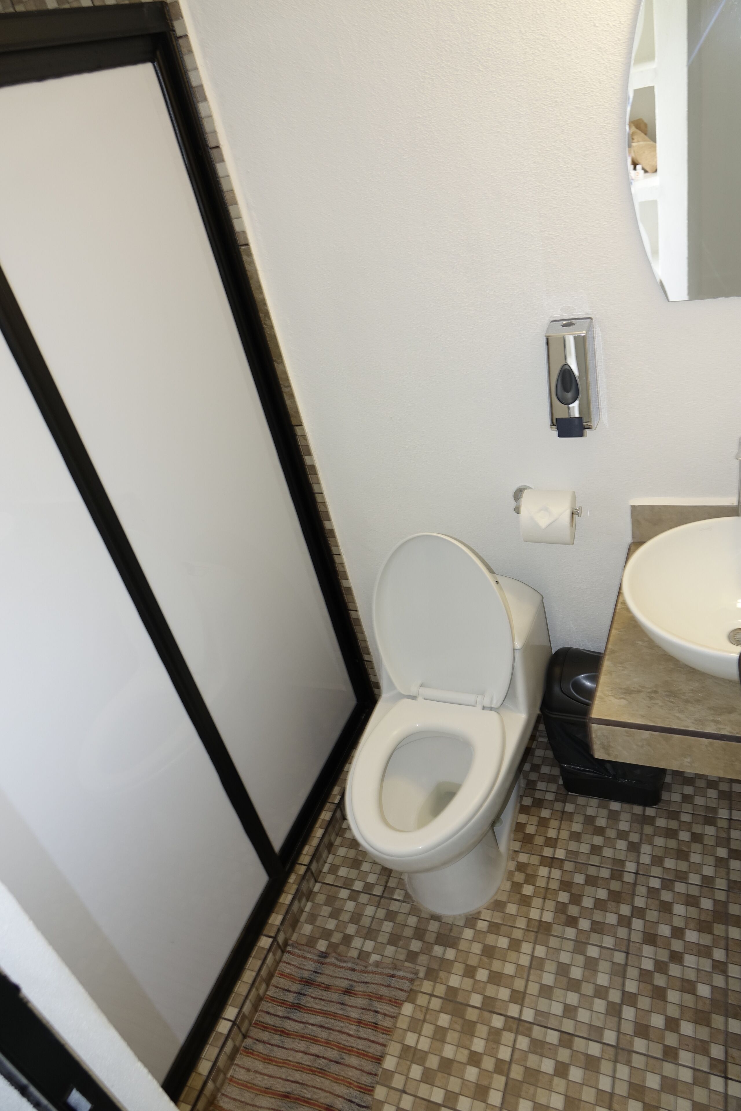Un baño pequeño con inodoro, lavabo y espejo.