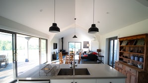A modern kitchen with a central island, a dining area, and a cozy living space. - Ravenscroft Cottage - Three Bedroom House, Sleeps 6 (Eccleston)