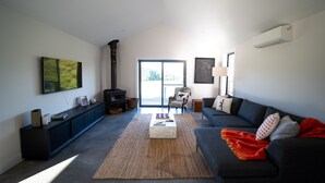 A spacious living room with a fireplace, a sofa, a coffee table, and a large window. - Ravenscroft Cottage - Three Bedroom House, Sleeps 6 (Eccleston)