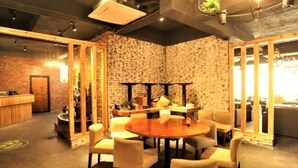 Un restaurante acogedor con pared de ladrillo, muebles de madera y una mesa redonda en el centro.