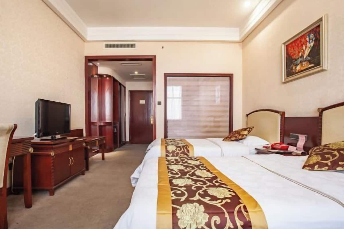 Une chambre d’hôtel équipée d’un lit, d’une télévision, d’un bureau et d’une armoire.