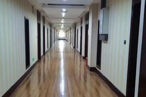 A long, narrow hotel corridor with doors on both sides, leading to individual rooms. - Taoyuan International Hotel (Yuncheng)