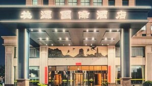 A hotel entrance with a large sign, a covered entrance area, and a glass door. - Taoyuan International Hotel (Yuncheng)
