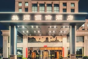 A hotel entrance with a large sign, a covered entrance area, and a glass door. - Taoyuan International Hotel (Yuncheng)
