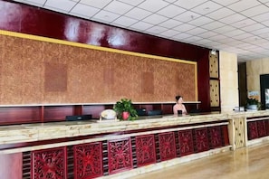 A reception desk with a marble top and intricate red paneling. - Taoyuan International Hotel (Yuncheng)