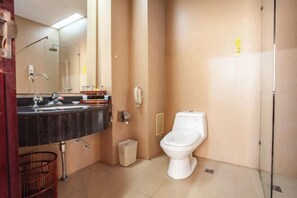 Une salle de bain avec des toilettes, un lavabo et un miroir.