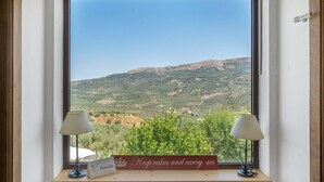 A window with a view of a vineyard and a sign that reads "Keep calm and carry on." - La Casa 1950 Montefrío by Ruralidays (Granada)
