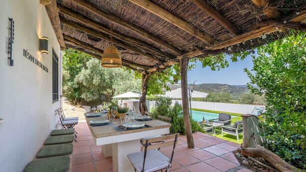 An outdoor dining area with a pergola, a pool, and a view of the countryside. - La Casa 1950 Montefrío by Ruralidays (Granada)
