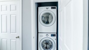 Una sala de lavandería con dos lavadoras apiladas.