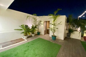 A courtyard with artificial grass, potted plants, and a wooden deck. - Aurora Suites Pasay near Airport (Pasay)