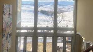 Una stanza con un'ampia finestra che si affaccia su un paesaggio innevato.