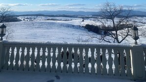 Paesaggio innevato con cielo sereno e montagne in lontananza.