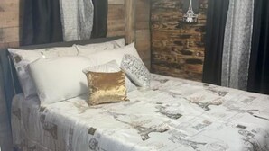 Un dormitorio con cama, almohadas y un cabecero decorativo.