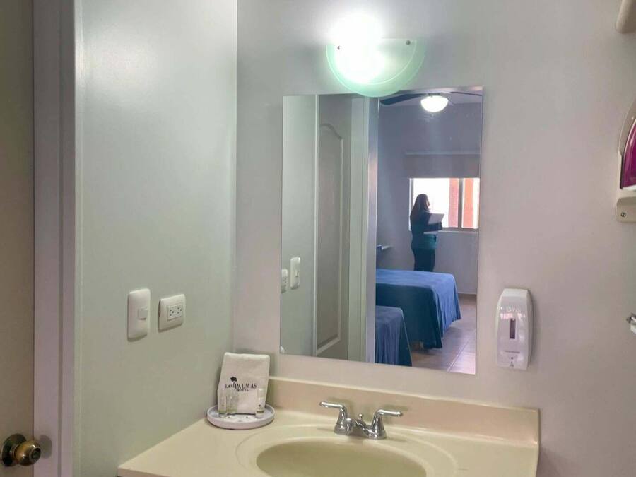 A bathroom with a sink, mirror, and a towel rack with a towel.