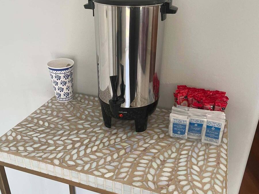 Una tetera eléctrica de acero inoxidable sobre una mesa con baldosas de diseño decorativo.