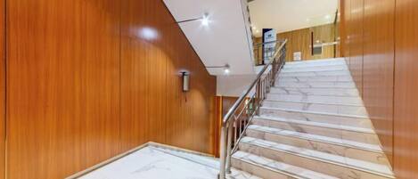 A staircase with wooden walls and marble steps.