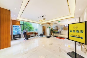 A hotel lobby with a reception desk, seating area, and a sign indicating the direction to the restaurant. - Jinsheng Hotel (Guangzhou Xiancun Metro Station) (Guangzhou)