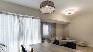 A modern living room with a dining table, chairs, a sofa, and a small stool. - Harbor & Sea View Agaete (Puerto de las Nieves)