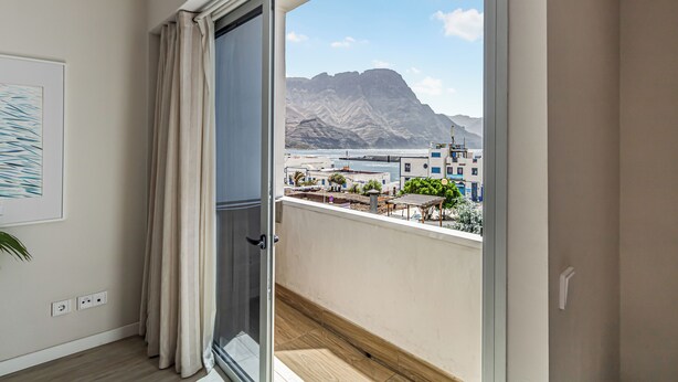 A balcony with a view of a mountainous landscape and a coastal area. - Harbor & Sea View Agaete (Puerto de las Nieves)