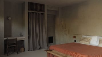 Un dormitorio con cama, escritorio y silla.