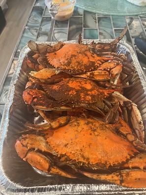 En bakke med kogte krabber på et bord.