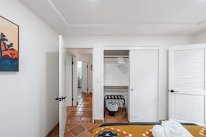 A hotel room with a bed, a door, a hallway, and a bathroom. - Blue Coyote Whole House (Yucca Valley)