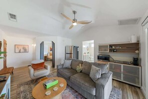 A living room with a sofa, coffee table, and a ceiling fan.