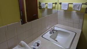 Ein Badezimmer mit Waschbecken, Spiegel und Handtuchhalter.