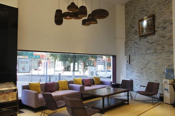 Un interior moderno con sofá, sillas, una mesa y lámparas colgantes.