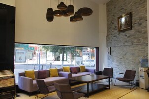 A modern interior with a sofa, chairs, a table, and pendant lighting.