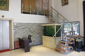 Un interior moderno con una escalera, un acuario y un escritorio.
